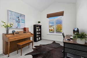Office area with vaulted ceiling and carpet flooring