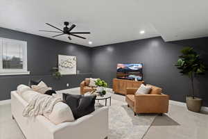 Carpeted living room featuring baseboards and ceiling fan