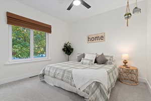 Carpeted bedroom with baseboards and a ceiling fan
