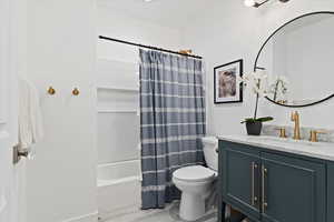 Bathroom with shower / tub combo with curtain, vanity, and light wood-style flooring