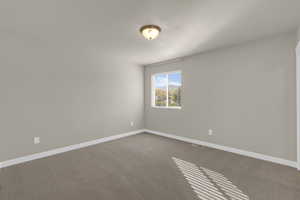 Empty room with carpet flooring and baseboards