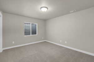 Carpeted empty room featuring baseboards and a textured ceiling