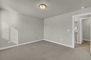 Unfurnished room featuring carpet and baseboards