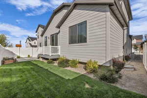 Rear view of property with a fenced backyard and a deck