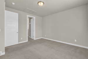 Unfurnished bedroom featuring carpet, attic access, and connected bathroom