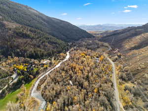 Aerial overview of property's location with mountains and a heavily wooded area