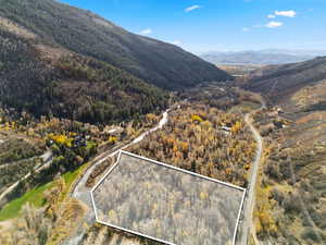Aerial view of property's location with a mountainous background and property boundaries highlighted