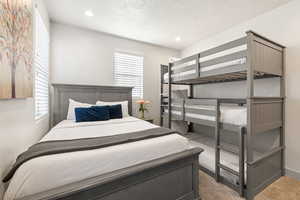 Bedroom featuring carpet, a textured ceiling, and recessed lighting