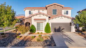 Mediterranean / spanish home featuring concrete driveway, stucco siding, a tile roof, and brick siding