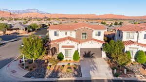 Mediterranean / spanish home with a residential view, a tile roof, driveway, and stucco siding