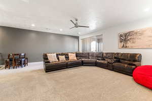 Living area featuring carpet flooring, recessed lighting, ceiling fan, and a textured ceiling