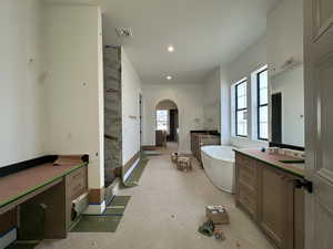 Full bath featuring a freestanding tub, two vanities, and recessed lighting