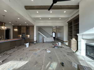 Unfurnished living room featuring beam ceiling, a  gas fireplace, ceiling fan