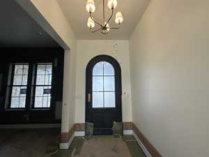 Foyer featuring a chandelier next to room at entrance