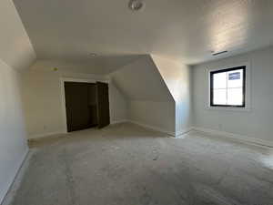 Bonus room featuring baseboards and lofted ceiling
