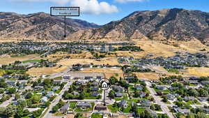 Aerial view of property's location featuring nearby suburban area and a mountain backdrop