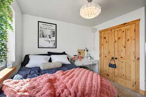 Carpeted bedroom featuring a chandelier
