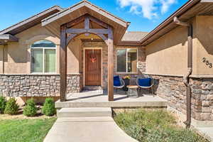 Property entrance featuring stone siding and stucco siding