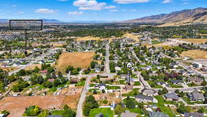 Aerial view of property's location featuring nearby suburban area and a mountainous background