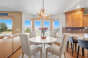 Dining space featuring a textured ceiling, light wood finished floors, and a chandelier