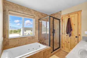 Bathroom with a tub with jets, a shower stall, double vanity, a mountain view, and a textured ceiling