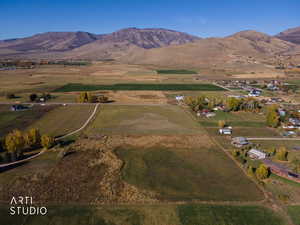 Aerial view of property and surrounding area featuring rural landscape and a mountain backdrop