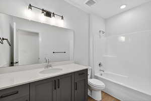 Full bathroom featuring vanity, light wood finished floors, bathing tub / shower combination, and recessed lighting
