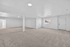 Basement with light carpet and baseboards