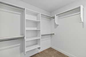 Spacious closet with light colored carpet