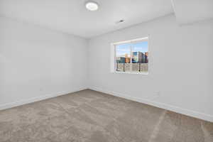 Unfurnished room featuring light carpet and baseboards