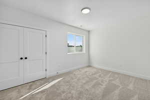 Unfurnished bedroom with carpet, a closet, and a textured ceiling