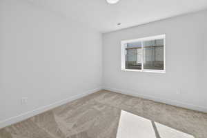 Carpeted empty room with baseboards