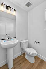 Half bathroom featuring light wood-style flooring and baseboards