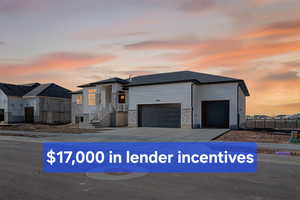 View of front of house with stone siding, a garage, and concrete driveway