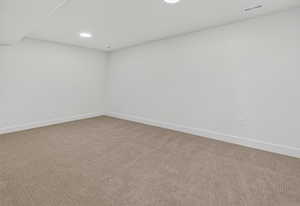 Spare room featuring light colored carpet and recessed lighting