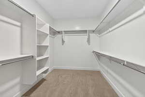 Spacious closet with light colored carpet
