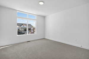 Spare room featuring carpet floors and baseboards