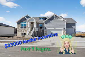 View of front of house with board and batten siding, stone siding, driveway, and a shingled roof
