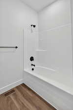 Bathroom with wood finished floors and  shower combination