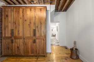 Corridor featuring light wood-style flooring and baseboards