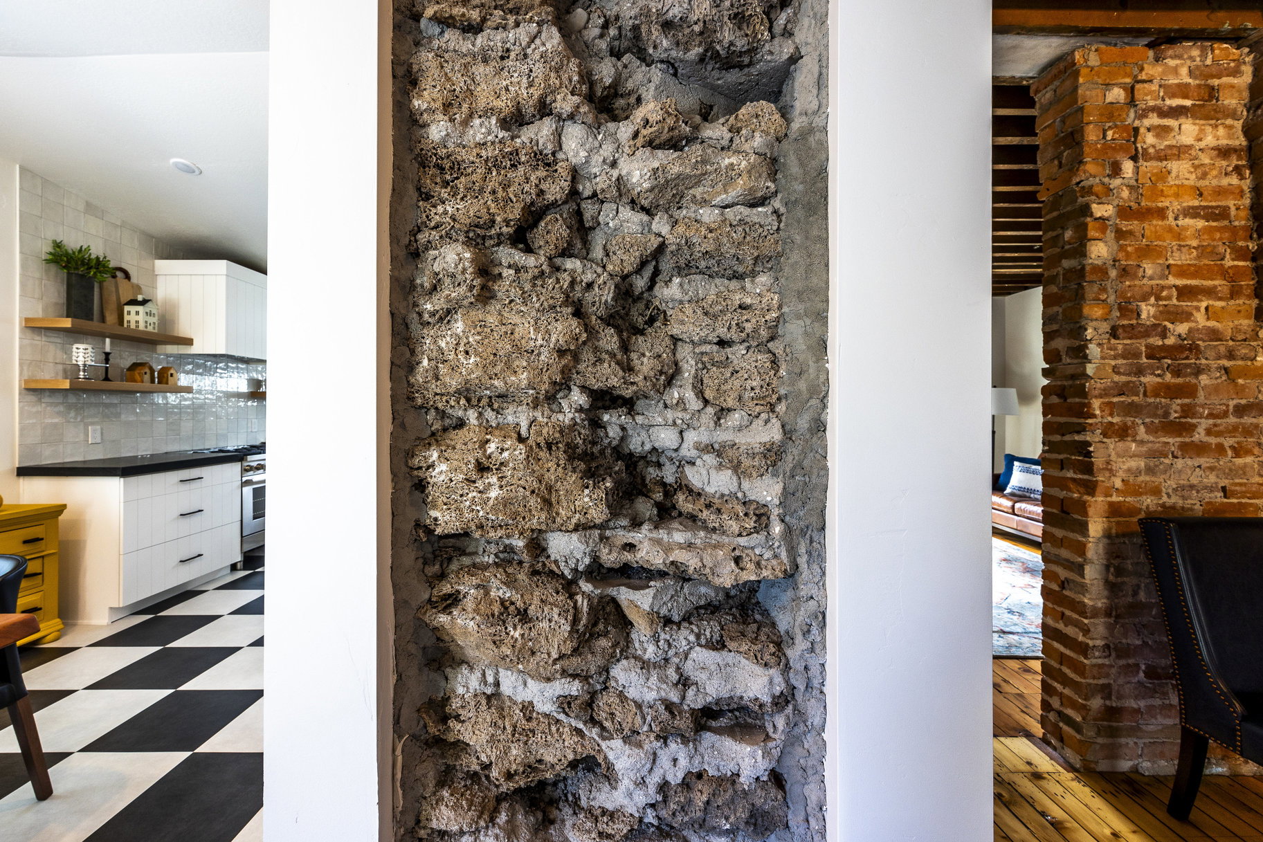 Detailed view of decorative backsplash, tile patterned floors, and stainless steel oven
