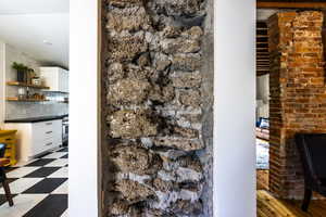 Detailed view of decorative backsplash, tile patterned floors, and stainless steel oven