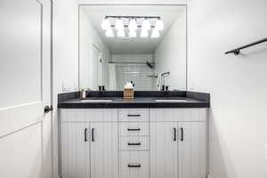 Bathroom with double vanity and a shower with shower curtain