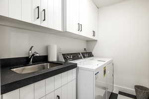 Laundry room featuring washer and clothes dryer and cabinet space