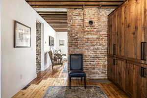 Living area featuring wood-type flooring and beam ceiling