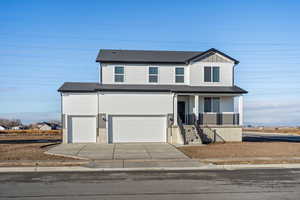 View of front of property with a porch, concrete driveway, a garage, and roof with shingles
