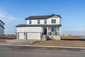 View of front facade featuring concrete driveway, a porch, an attached garage, and board and batten siding