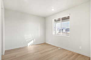 Unfurnished room featuring light wood-style floors and baseboards