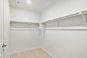 Spacious closet featuring light colored carpet