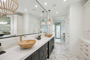 Bathroom with double vanity, a stall shower, and recessed lighting